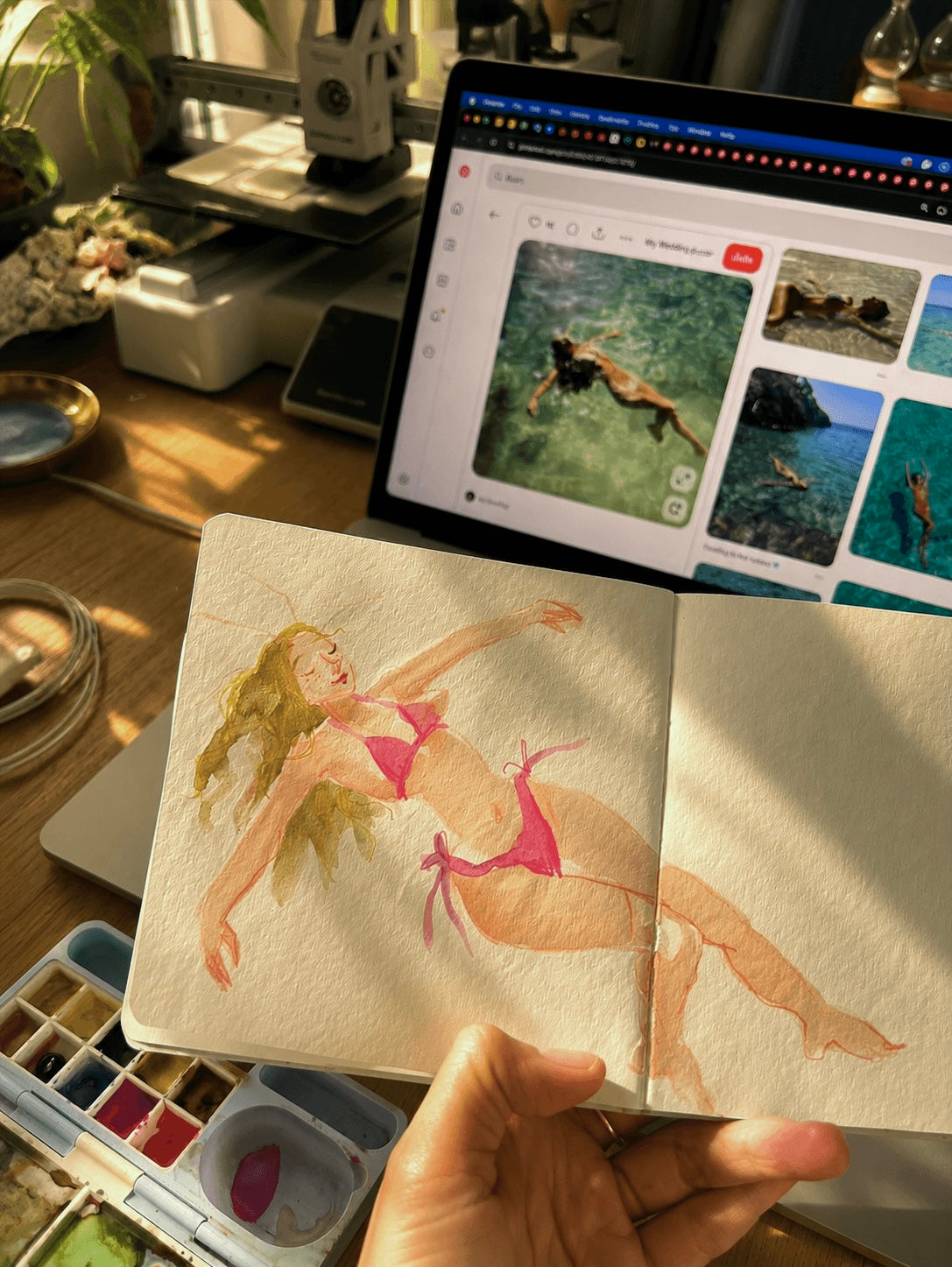 Watercolour sketchbook — painted figure with MacBook Pinterest board in background